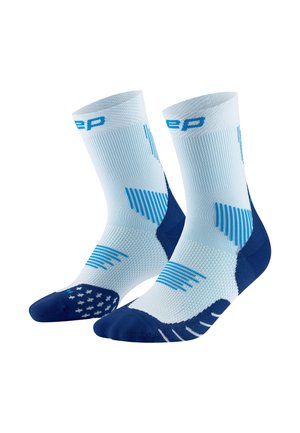 Hellblaue Sportstrümpfe mit blauen Akzenten, die eine gerippte Textur und gemusterte Griffe auf der Sohle für bessere Traktion aufweisen.