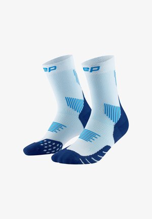 Hellblaue Sportstrümpfe mit blauen Akzenten, die eine gerippte Textur und gemusterte Griffe auf der Sohle für bessere Traktion aufweisen.
