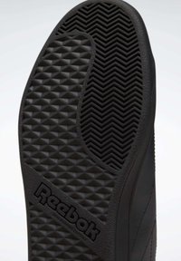 Černá gumová podrážka obuvi se zigzagovým a trojúhelníkovým vzorem, s logem "Reebok" a designem nezanechávajícím stopy.