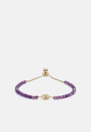 Gouden armband met kleine paarse kralen en een gouden oogvormige bedel met een centrale heldere steen.