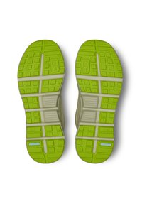 Semelles de chaussures de course vertes et grises avec des motifs et rainures texturés, comportant un logo. Fabriquées avec un matériau léger et flexible.