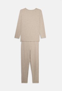 Beige långärmad topp och åtsittande byxor set, tillverkat av mjukt, strukturerat tyg med rund halsringning och elastisk midja.