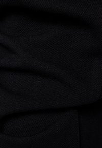 Black knitted fabric with a soft texture, featuring subtle ribbing and gentle folds. No visible patterns or hardware details.