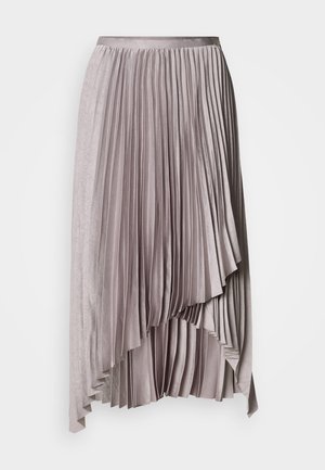 Saia plissada assimétrica em malva claro com cinto de cetim e bainha em camadas em cascata contra fundo liso.