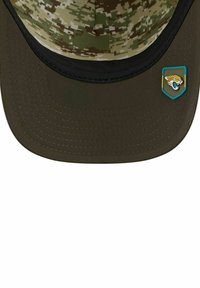 Hut mit einem Camouflage-Muster in Grüntönen, einer flachen Krempe und einem dunklen Unterrand; enthält ein Logo-Flag im Eck.