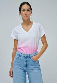 Camiseta de algodón blanca con un degradado ombré rosa, diseño de escote en V y mangas cortas, combinada con unos vaqueros de mezclilla de tiro alto en azul claro.