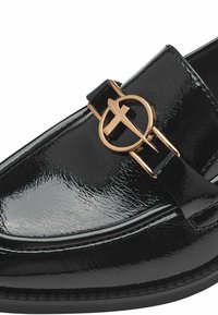 Mocassino in pelle verniciata nera con dettagli in cinturino e fibbia circolare dorata. La scarpa ha una finitura liscia e lucida e una suola piatta.