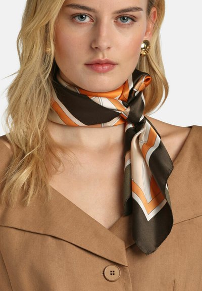 Svila šal u smeđoj, narančastoj i krem boji s geometrijskim uzorkom. Glatka tekstura, uredno vezan oko vrata. Upotpunjen bež odjećom.