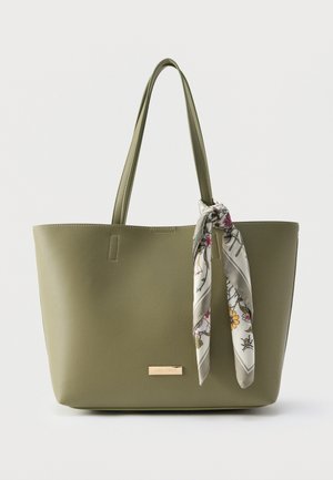 Sac cabas vert olive avec double poignées et une écharpe à motif floral attachée à une poignée.