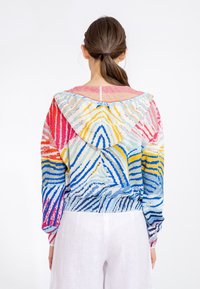 Knit pullover with multicolored wave pattern in blue, pink, yellow, and white. Features a hood and elastic waistband. Long sleeves.