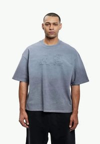 T-shirt de manga curta, corte solto, em tecido macio e cinza claro, apresentando letras em relevo na frente e decote redondo.