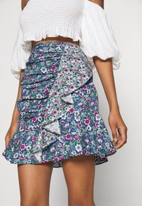Gonna a foulard con orlo arricciato, prevalentemente blu scuro con motivi floreali verdi, rosa e bianchi, realizzata in tessuto leggero.