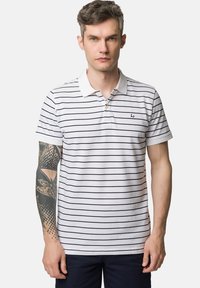 Biała koszulka polo w granatowe paski, krótki rękaw, kołnierzyk i małe logo na piersi. Miękki materiał bawełniany o klasycznym kroju.