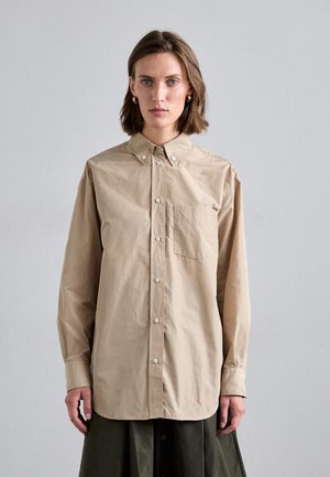 Beige button-up shirt made of cotton blend, featuring a collar, long sleeves, and a chest pocket. Smooth texture, classic fit.