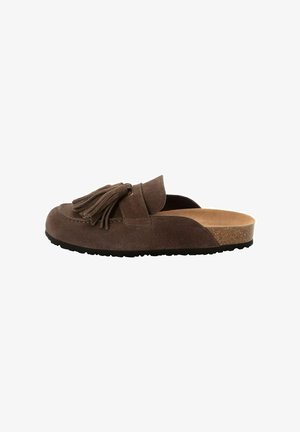 Brauner Wildleder-Slipper mit Quasten, Kork-Fußbett und schwarzer Gummisohle, in Seitenansicht vor weißem Hintergrund gezeigt.