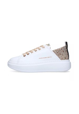 Scarpe sportive bianche con un accento dorato testurizzato sul retro, caratterizzate da occhielli e lacci dorati e una suola spessa bianca.