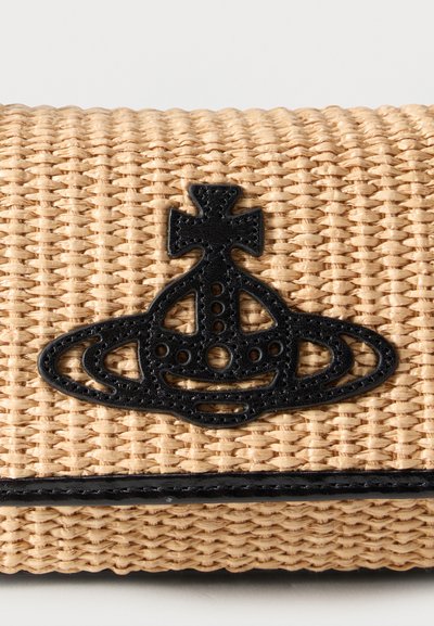 Πλεκτό μπεζ ορθογώνιο clutch με μαύρο κεντημένο έμβλημα σφαίρας και μαύρο τελείωμα κατά μήκος της κάτω άκρης σε λευκό φόντο.