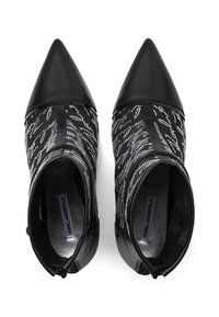 Mustad pahklisaapad terava ninaga, millel on tekstureeritud ülemine osa, mis on kaunistatud hõbedaste dekoratiivmustritega ja siledast nahast kand.