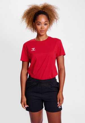 Rode katoenen T-shirt met ronde hals en korte mouwen, voorzien van een wit logo op de linkerborst. Gecombineerd met zwarte shorts met elastische tailleband.