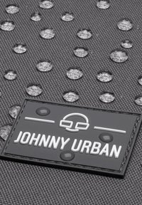 Material textil negru cu o suprafață texturată, decorată cu picături de apă. Patch de cauciuc alb cu logo-ul "JOHNNY URBAN" și accente, în formă rectangulară.