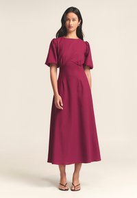 Burgundin midi-mekko, jossa on lyhyet puffihihat, istuva yläosa ja A-linjainen hame; kevyt kangas, jolla on sileä rakenne.