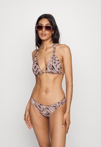 Biquíni com padrão rosa e castanho, com um top triangular e alças atadas. As partes de baixo combinantes apresentam um design de cintura baixa e bordas sem costura.