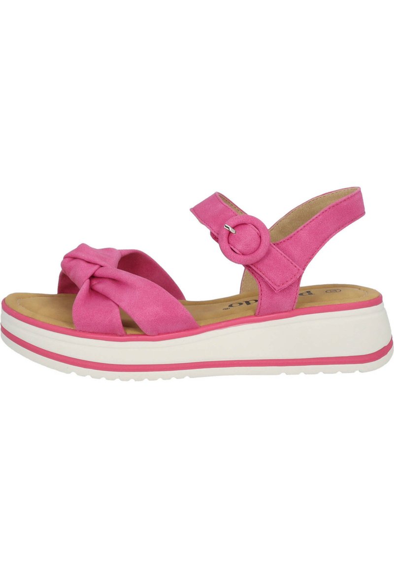 Sandali in suede rosa con un design frontale annodato, cinturino alla caviglia regolabile e suola piatta bianca con una linea di accento rosa.