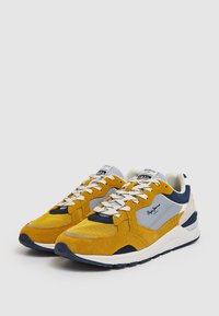 Sneakers gialli e blu navy con un upper in suede e mesh, dotati di collare imbottito, chiusura con lacci e accentuazione del logo di lato.
