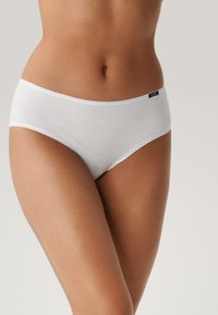 Białe bawełniane majtki hipster wykonane z gładkiego materiału z logo na gumce w pasie, zaprojektowane z myślą o wygodzie i zakryciu.