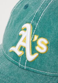 Boné de algodão verde com o logótipo "A's" bordado em branco e amarelo, com costura detalhada e um acabamento ligeiramente texturizado.