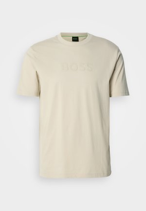 Cremefarbenes T-Shirt aus Baumwolle mit Rundhalsausschnitt und kurzen Ärmeln. Das "BOSS"-Logo ist auf der Vorderseite geprägt. Glatte Textur.