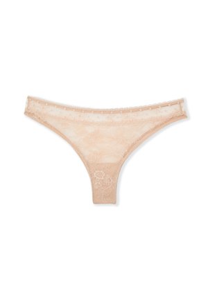 Tanga en dentelle beige avec motifs floraux et bords festonnés sur fond blanc.