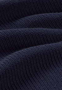 Tissu tricoté bleu marine avec une texture côtelée, présentant des lignes surélevées régulièrement espacées courant parallèles pour une apparence structurée.