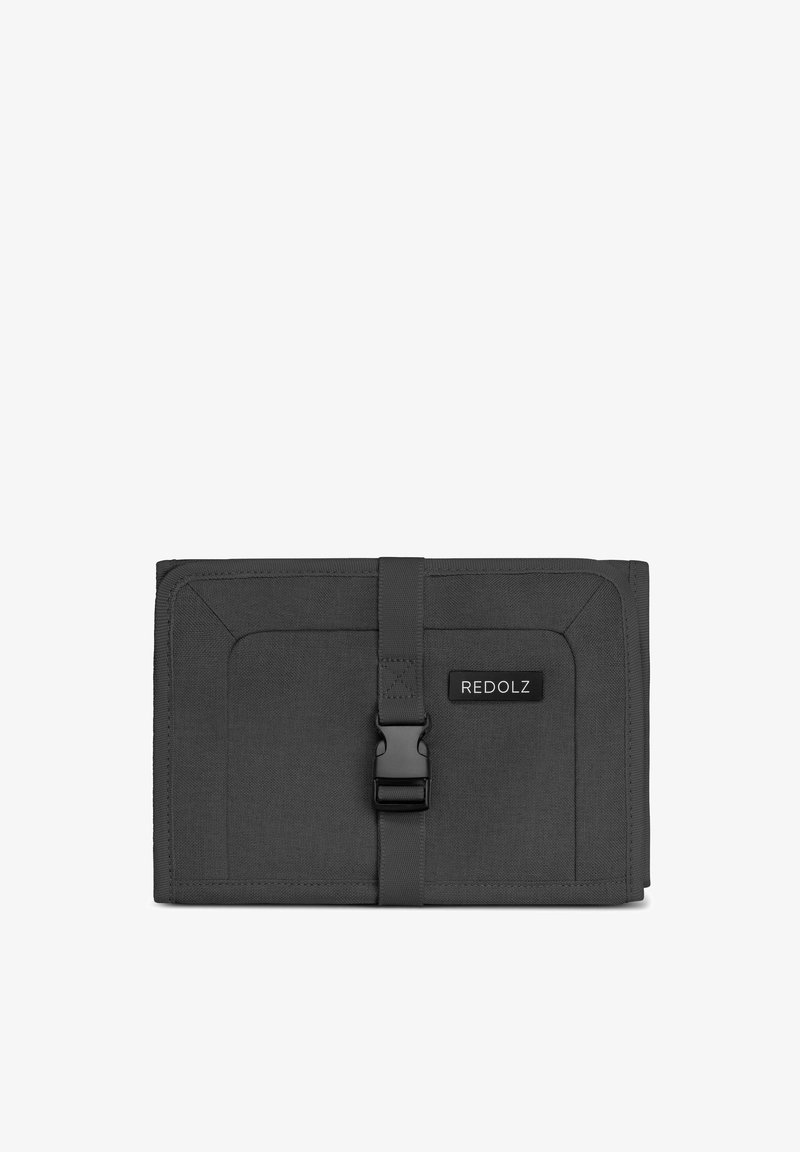 Grijze stoffen portemonnee met een textuur, voorzien van een sluiting met een gesp en een zwart etiket met de tekst "REDOLZ." Rechthoekige vorm, minimalistisch ontwerp.