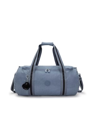 Blue duffel bag in a soft, textured material with dual black stripes. Features silver zippers and a black pom-pom keychain.