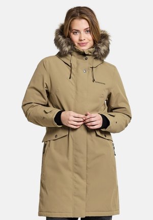 Tan parka-jacka med en foder av päls i huvan, framzip, tryckknappar och sidofickor. Har en slät yta och justerbara dragsnören.