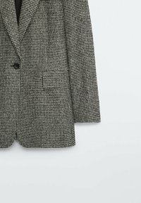 Geruite blazer in zwart en wit, met een enkele knoopsluiting, geknipte revers en een zak aan de voorkant links.