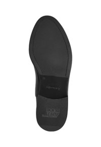 Schwarze Schuhsohle mit strukturiertem Gummioberfläche, die im hinteren Bereich einen glatten, matten Abschnitt und ein geprägtes Logo in der Mitte aufweist.