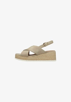 Sandal plataforma bege com design de tiras cruzadas, tira ajustável no tornozelo, sola intermédia texturizada tecida e sola de borracha branca.