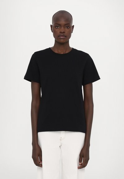 Black short-sleeve t-shirt in cotton fabric with a round neckline, displayed on a model against a plain white background.