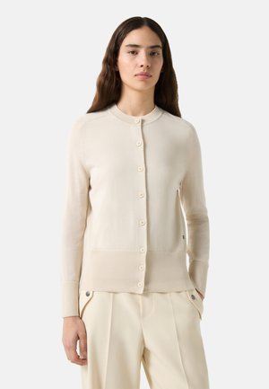 Beige cardigan lavet af blødt strikstof, med rund halsudskæring, lange ærmer og frontlukning med knapper i matchende farve.
