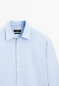 Lichtblauwe en witte verticaal gestreepte overhemd met lange mouwen, met een puntige kraag en witte knopen, gelabeld Massimo Dutti.