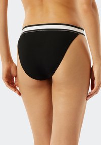 Czarne, żebrowane majtki bikini z szerokim, białym paskiem w talii i wysokimi wycięciami na nogawkach, charakteryzujące się gładką fakturą i minimalnym zakryciem.