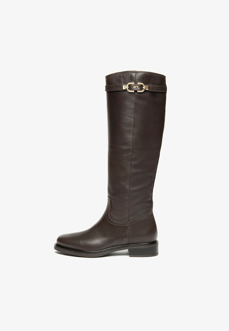 Botte en cuir marron, montante, avec un bout arrondi, un design épuré, une texture subtile et un accent en métal doré en haut. Semelle plate.