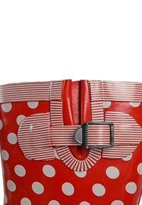 Red rubber rain boot featuring white polka dots, striped red and white accents, and a decorative buckle detail at the top.