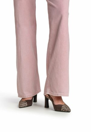 Benedenbenen met lichtroze wijd uitlopende broekspijpen en bruine slingback pumps met hoge hak en slangenhuidpatroon op de puntige neuzen.