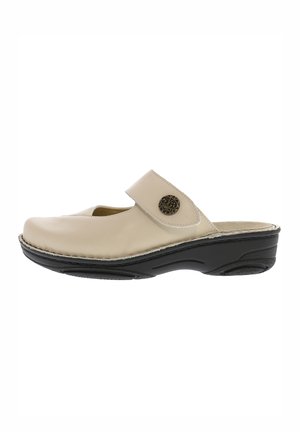 Zoccolo slip-on in pelle beige con cinturino regolabile decorato con un bottone e suola imbottita nera progettata per il comfort.