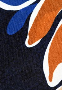 Patterned fabric featuring large blue, orange, and white floral shapes against a dark background; texture is smooth and knit.