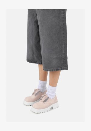 Heledad roosa nahast jalanõud valgete platvormsadega, millel on nööpimise disain ja hõbedane riistvara, kanda valgete ribadega pahkluudel sokkidega ja hallide cullote'itega.