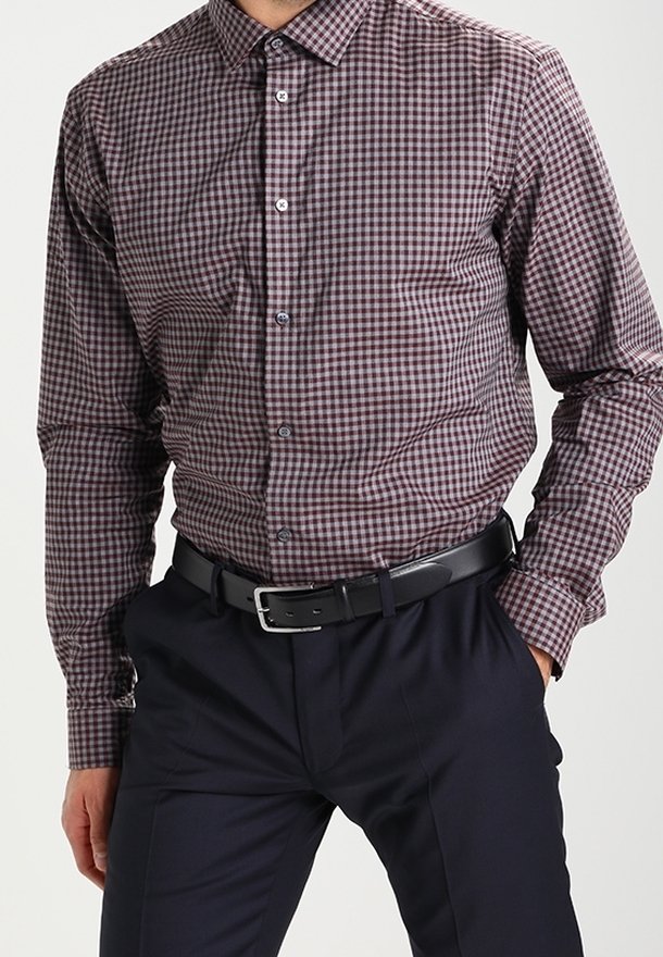 Camicia a maniche lunghe a quadri in borgogna e bianco, realizzata in tessuto intrecciato. Presenta un colletto button-down e bottoni frontali, abbinata a pantaloni neri.